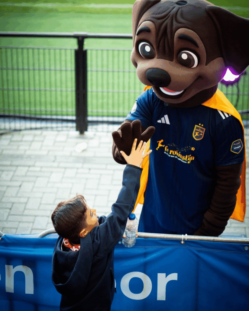 je ziet de mascotte van fc robinstijn een highfive geven aan een fan