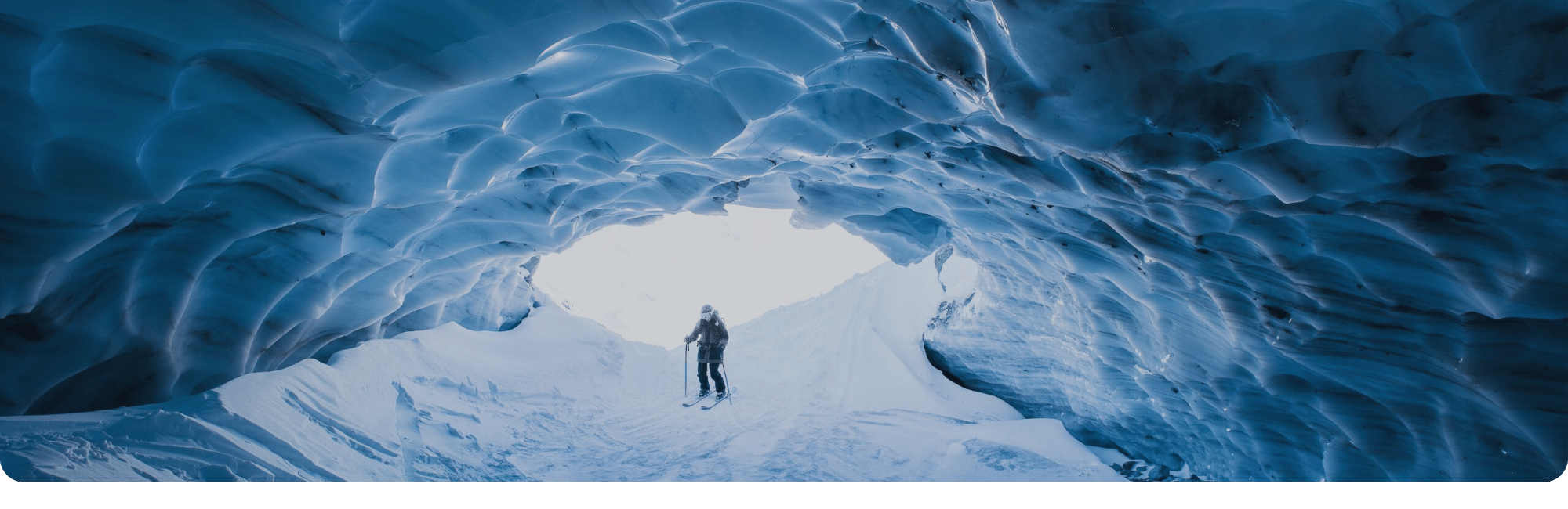 snow-sneeuwcave je ziet een skieer in de bergen onder een ijsmuur